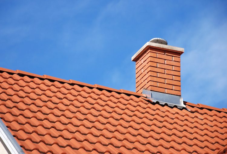 smoke stack on the tiled roof of a family house